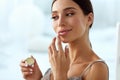 Lips Skin Care. Woman With Beauty Face Applying Lip Balm On