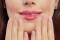 Lips with trendy color glossy lipgloss makeup. Beautiful female mouth and perfect manicured nails