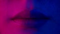Lips of Woman in Colourful Neon Lighting. Make-Up Advertisement in Room with Black Background. Fashion Makeup on Skin of