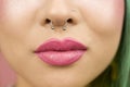 Lips of young woman wearing pink lipstick