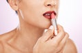 Lipstick application, woman and mouth on studio background for beauty, fashion and aesthetics. Closeup female model, red