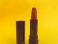 Lipstick in a black compact package on a yellow matte background. bright red lipstick, shade creation, lip hydration. stylish and