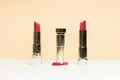 Lipstick different colors, shades options. Cosmetics on nude background. Beautiful examples of lipsticks, pink and red. One
