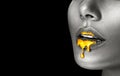 Lipstick dripping. Paint drips, lipgloss dripping from sexy lips, liquid Gold metallic paint drops on beautiful model girl`s mouth Royalty Free Stock Photo