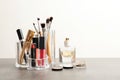 Lipstick holder with different makeup products on table against white background. Royalty Free Stock Photo