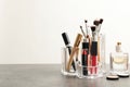 Lipstick holder with different makeup products on table against white background. Royalty Free Stock Photo