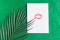 Lipstick kiss on white blank, minimal concept, green glitter background.