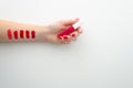 Lipstick makeup swatches on woman female hand holding lipstick, flat lay. Royalty Free Stock Photo