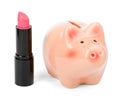 Lipstick with piggy bank on white