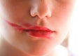 Lipstick smeared on the lips. Young attractive teenager girl doing make-up Royalty Free Stock Photo