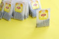 Lipton Yellow Label black tea bags on pastel yellow surface close up. Lipton is a world famous brand of tea