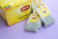 Lipton Yellow Label black tea pack and teabags on pastel lilac surface close up. Lipton is a world famous brand of tea