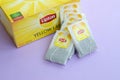 Lipton Yellow Label black tea pack and teabags on pastel lilac surface close up. Lipton is a world famous brand of tea