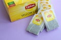 Lipton Yellow Label black tea pack and teabags on pastel lilac surface close up. Lipton is a world famous brand of tea