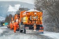 Liptovsky Hradok, Slovakia - February 12, 2020: Group of bright orange highway maintenance trucks with de icing salt getting ready
