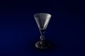 3D illustration of liqueur or vermouth glass on dark blue design background - drinking glass render