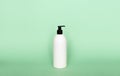 Liquid container for gel, lotion, cream, shampoo, bath foam. Cosmetic plastic bottle with dispenser pump on green Royalty Free Stock Photo
