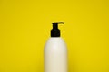 Liquid container for gel, lotion, cream, shampoo, bath foam on yellow background. Cosmetic plastic bottle with white Royalty Free Stock Photo