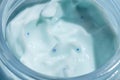 Liquid cream cosmetic smudge blue micro capsules microsphere texture in glass jar macro close up Royalty Free Stock Photo