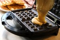 Liquid dough poured waffle iron machine to prepare sweat Belgian waffle dessert.