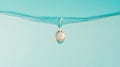 Liquid drop hangs beneath smooth water surface against a soft teal background. Clarity and light reflect in sphere shape. Close Royalty Free Stock Photo