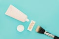 Liquid fluid foundation in tube on makeup sponge and brush makeup on blue background Royalty Free Stock Photo