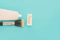 Liquid fluid foundation in tube on makeup sponge and brush makeup on blue background Royalty Free Stock Photo