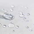 Liquid gel or serum pipette with drops on gray background