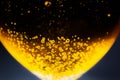 Liquid gold-yellow gasoline bubbles background on beer or champagne glass. Close up, macro shot. Soft focus photo Royalty Free Stock Photo