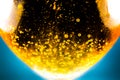 Liquid gold-yellow gasoline bubbles background on beer or champagne glass. Close up, macro shot. Soft focus photo Royalty Free Stock Photo