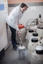 Liquid nitrogen technician fills container Royalty Free Stock Photo