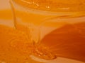 Liquid shower gel flows gracefully across a bright orange background.