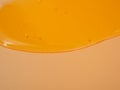 Liquid shower gel flows gracefully across a bright orange background.