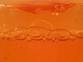 Liquid shower gel flows gracefully across a bright orange background.
