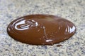 Liquid tempered chocolate poured on a granite table Royalty Free Stock Photo