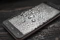 Liquid water drops on glass of smartphone