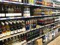 Liquor bottles in rows of aisles and shelves in supermarket.