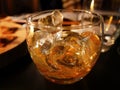 Liquor glass with ice on dark table, yellow amber alcoholic beverage. Whiskey, single malt, Brandy, scotch, cognac, bourbon Royalty Free Stock Photo