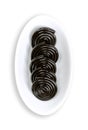 Liquorice wheels, black licorice confection, in an oval white bowl Royalty Free Stock Photo