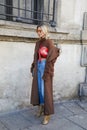 Lisa Hahnbueck with brown coat, golden shoes and red Supreme pouch before Max Mara fashion show, Milan
