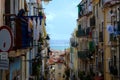 Lisbon narrow alley with old residential buildings and drying cloths Royalty Free Stock Photo