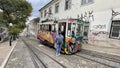 LISBON, PORTUGAL - APRIL 22, 2022: Lisbon yellow tram at the old town.Colorful architecture city buildings street scene.