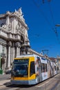 Lisbon, Portugal: Carris modern yellow tram and Rua Augusta Street Triumphal Arch in Praca do Comercio