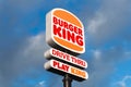 Burger King logo sign in the sky along a road, drive thru and play king, blue sky with clouds. Royalty Free Stock Photo