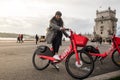 Lisbon, Portugal - December 14, 2019: Woman riding a rental bike of Jump electric bikes near of the tower of Belem in Lisbon. Jump