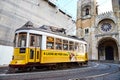 LISBON, PORTUGAL, 14, December, 2018: Wooden historical vintage yellow street tram 28 moving near  Lisbon Cathedral, symbol of Royalty Free Stock Photo