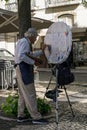 Lisbon, Portugal. 10.05.2023 Elderly artist painting on the street in the center of Lisbon
