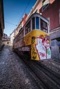 Lisbon, Portugal, January 25, 2020: Glory elevator tram full of graffiti on rails on a steep slope seen from the back