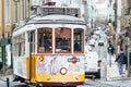 Lisbon, Portugal - January 17, 2020: Street car 28, the famous yellow tourist tram, makes its way up the narrow, steep streets of Royalty Free Stock Photo