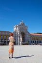 Vertical shot of a beatiful woman stood infront of the Arco da Rua Augusta